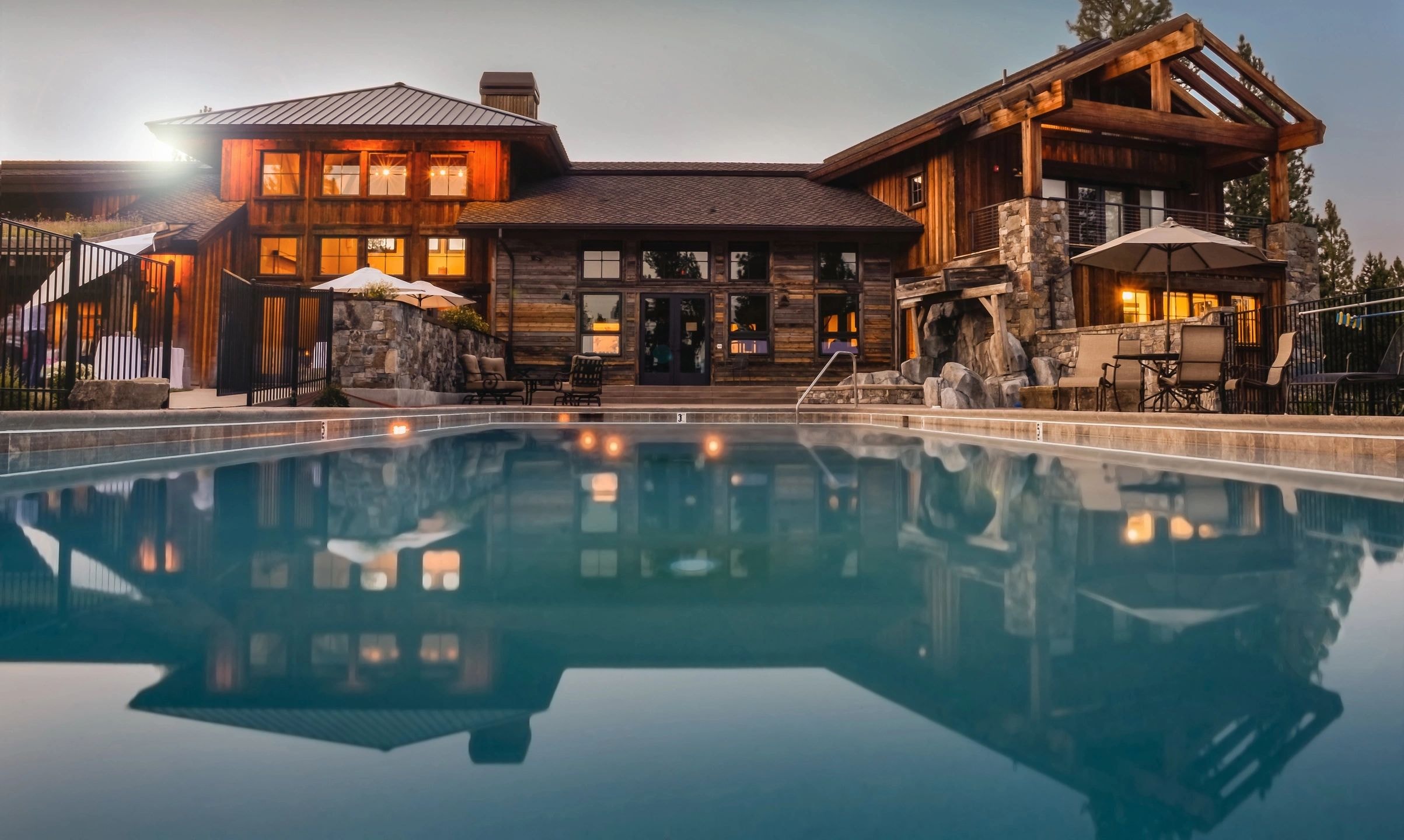 Luxury modern residential compound at dusk with infinity pool